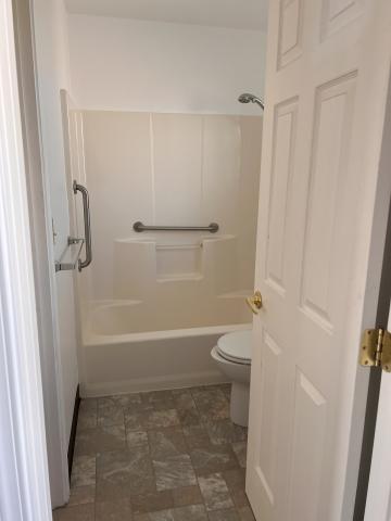 Upstairs bathroom with toilet and bathtub with shower